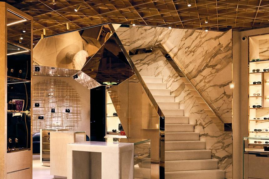 A boutique interior with a marble stair and lit display cases.