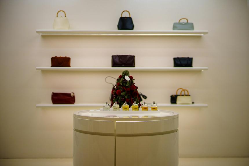 Cream boutique interior with handbags arranged on rounded shelves.